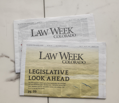 two Law Week Colorado newspapers stacked on top of a marble table
